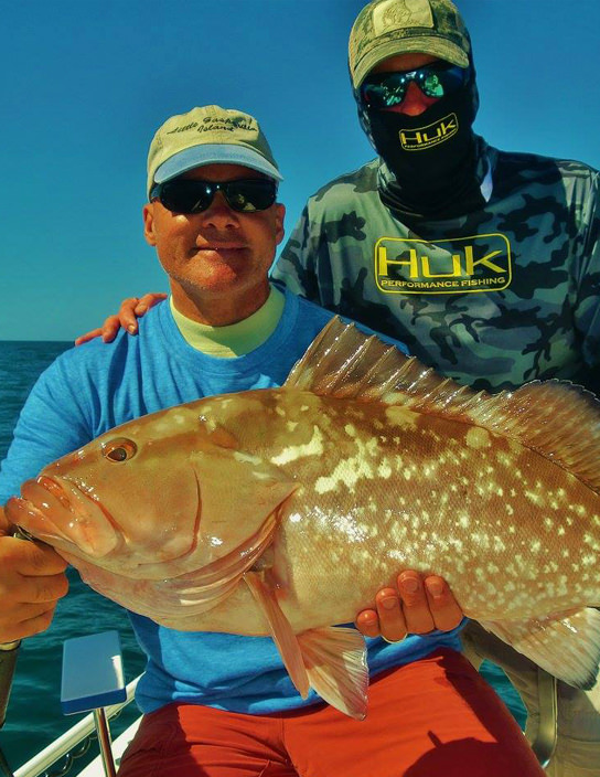 Capt Kelly with a man holding very large grouper.