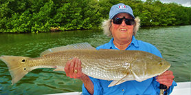 Smiling woman holding large fish.