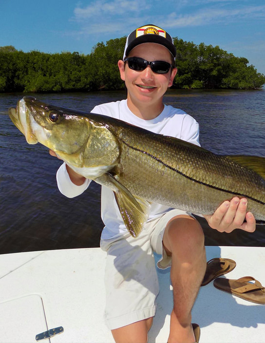 Young man holding large snook.